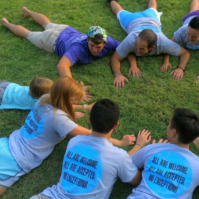 Students in a circle activity with a child