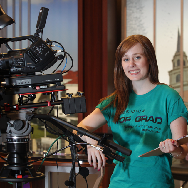 Student in FTDM studio with camera and clipboard