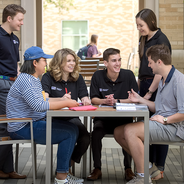 Neeley students sit at an outdoor table