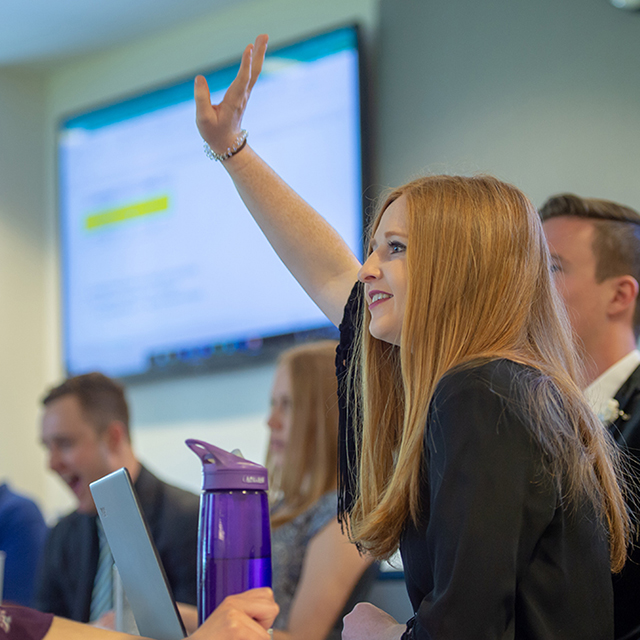 a future leader raises her hand in a Neeley classroom