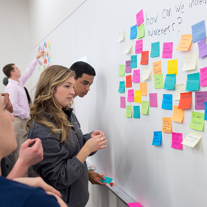 Students brainstorm using brightly colored sticky notes