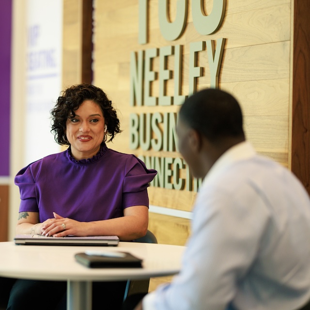 Woman smiles across the table to a man