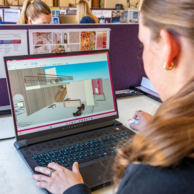 Student looks at laptop screen showing design mockup