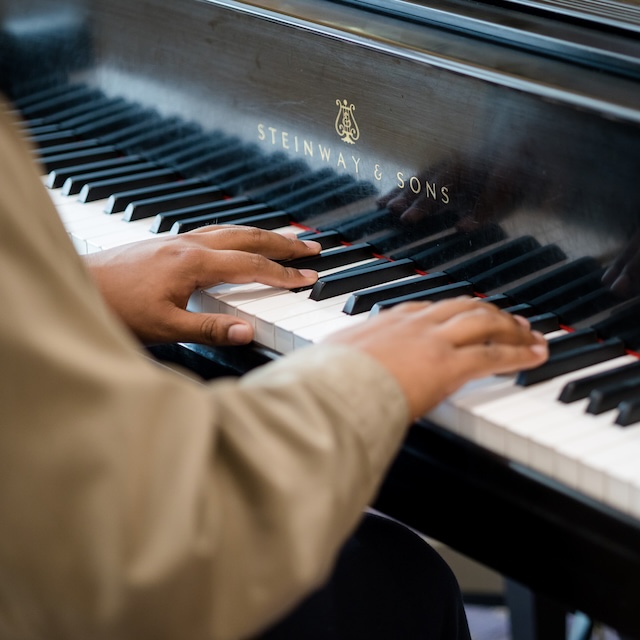 A pianist's hands hover over the keys