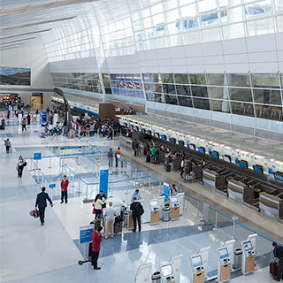 The ticketing counters inside a Dallas-Fort Worth International Airport terminal that features four-story-tall ceilings with abundant natural light