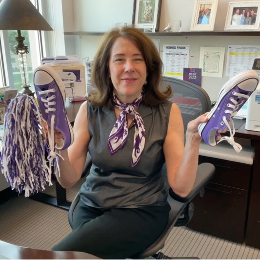 Jean Pickett holds up a pair of purple Converse shoes