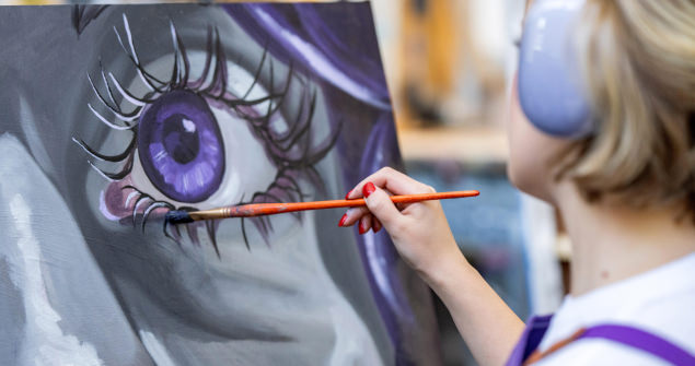 Student painting a large purple eye on canvas.