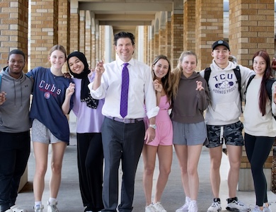 Chancellor Pullin and students showing Go Frogs hand signs