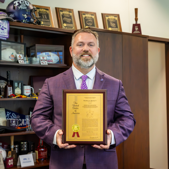 Reuben Burch holding a plaque of his 50th patent