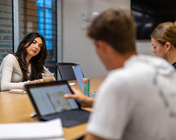 Three students collaborating in a study session room